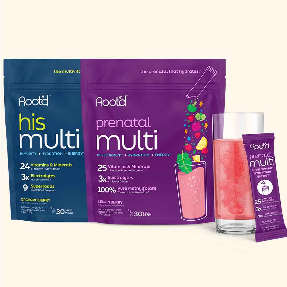 Root’d His Multi and Prenatal Multi supplement packs displayed side by side. His Multi in blue packaging provides 24 vitamins and minerals, 3x electrolytes, and 9 superfoods. Prenatal Multi in purple packaging provides 25 vitamins and minerals, 3x electrolytes, and 100% pure methylfolate. In front is a glass of pink drink and a single-serving stick pack of Prenatal Multi in lemon berry flavor.