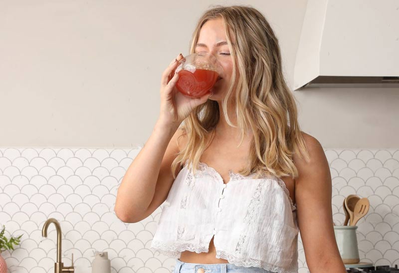 woman drinking Root'd sugar-free electrolytes