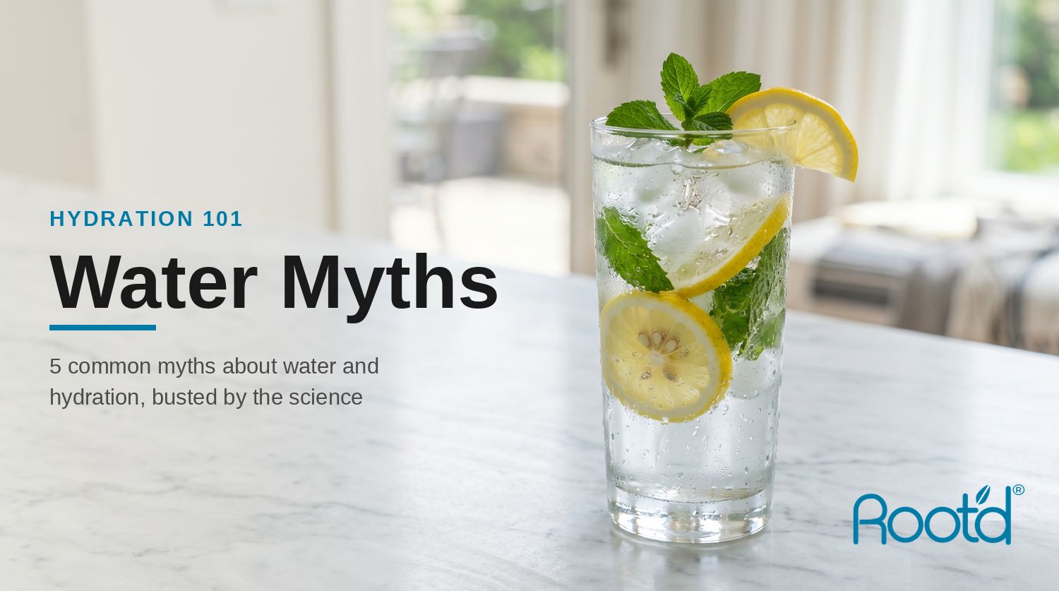 A tall glass of ice water with lemon and mint on a clean marble counter — water and hydration myths